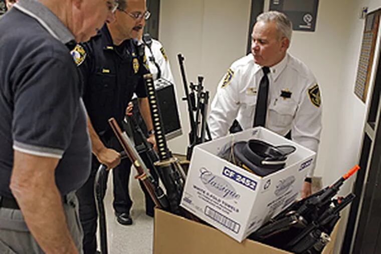 Weapons confiscated from a teenager's home are carried by Montgomery County Sheriff's deputies to the district attorney's press conference.