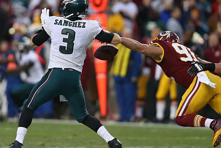 Redskins' Ryan Kerrigan strips the ball from the Eagles' Mark Sanchez during the 1st quarter. Philadelphia Eagles play the Washington Redskins at FedEx Field in Landover, MD on December 20,  2014.  (David Maialetti/Staff Photographer)