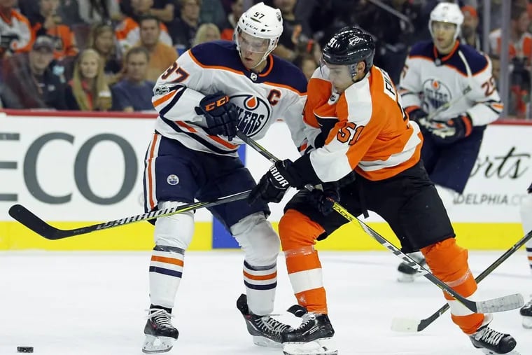 Oilers’ center Connor McDavid, left, and Flyers’ center Valtteri Filppula move to the loose puck during the second period.