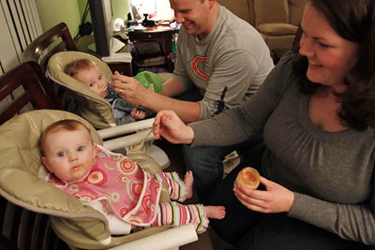 Stephanie Nash, with her husband Eric and twin babies Caroline, left, and Jack, 7-months-old, enjoy feeding time in their Downers Grove, Ill. home. The twins were conceived after the couple had suffered two miscarriages. (Phil Velasquez / Chicago Tribune / MCT)