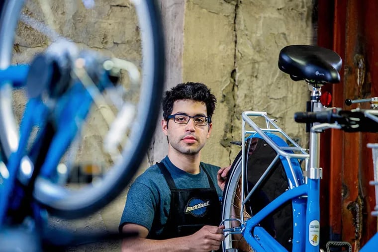 At Indego’s headquarters in Kensington, bike tech Jake Siemiarowski assembles one of the bicycles. “Our bikes are "purpose built" for city sharing and outdoor storage,” he says. (JEFF FUSCO/For the Inquirer)