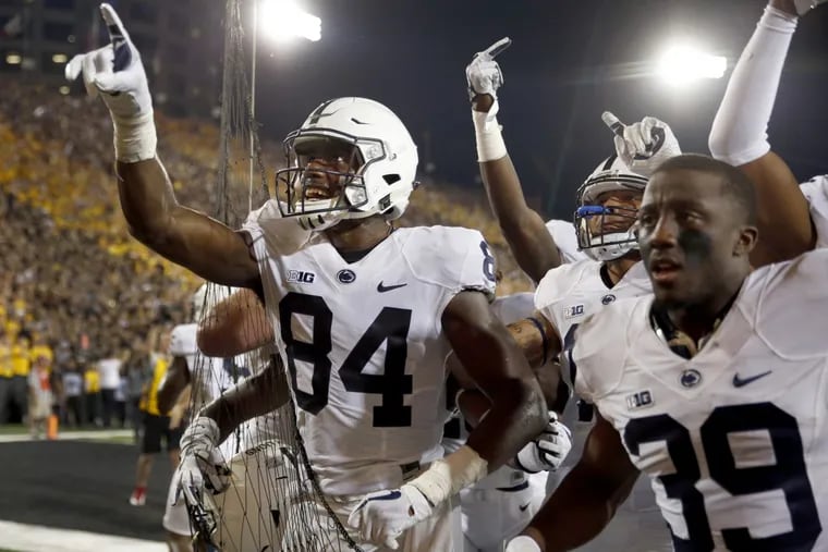 Penn State wide receiver Juwan Johnson (left) celebrates alongside teammates after catching the game-winning, walk-off touchdown pass against Iowa on the road.