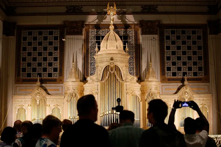 Spectators view newly refurbished Wanamaker pipe organ case from the second level of the Center City Macy's on Saturday. Macy's and Friends of the Wanamaker Organ unveiled the restoration on Saturday.