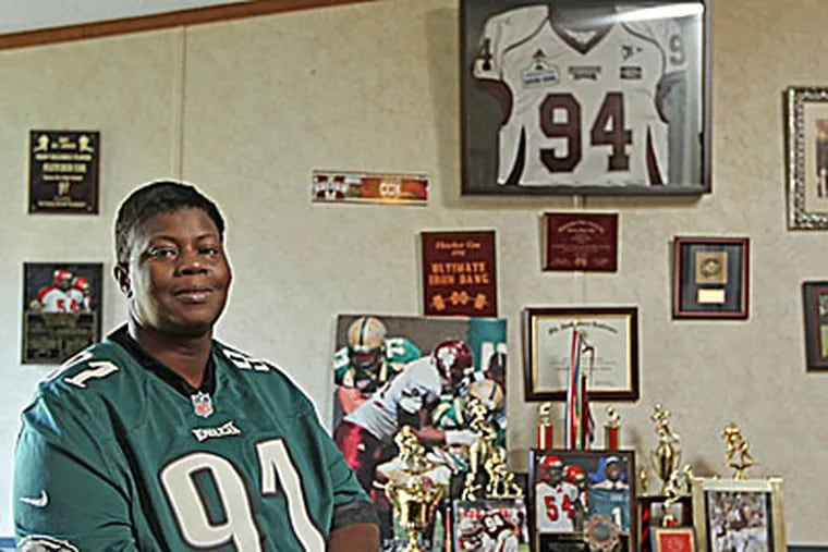 Fletcher Cox's mother, Melissa, sits in her living room filled with awards, trophies and photos. (Michael Bryant/Staff Photographer)