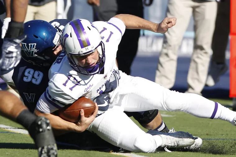 Quarterback Bryan Schor, (right) of James Madison is sacked by Ricky Young of Villanova in November.
