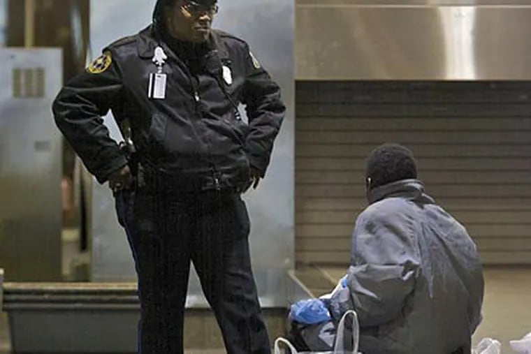 Officer Ida Allen talks to a man sitting on a baggage claim at Terminal B at Philadelphia International Airport in 2020, amid efforts by the city to clear encampments of people experiencing homelessness who were gathering at the airport. In early 2024, Mayor Cherelle L. Parker issued an RFP to find a vendor to “reduce the presence of homeless individuals” at the airport.