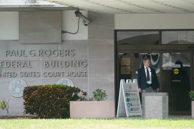 A security guard stands outside the Paul G. Rogers Federal Building and U.S. Courthouse in September in West Palm Beach, Fla.