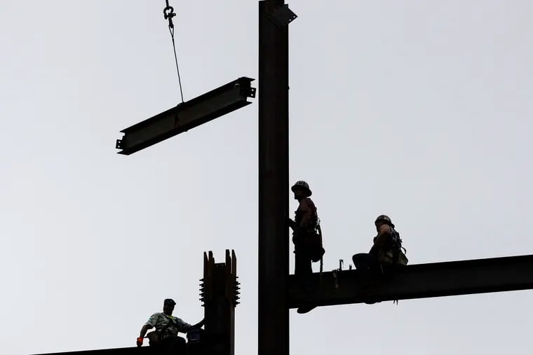 FILE- In this June 1, 2018 file photo ironworkers construct a commercial and residential building in Philadelphia. (AP Photo/Matt Rourke, File)