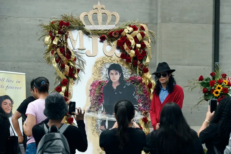 Michael Jackson impersonator Rem Garza of Long Beach, Calif., poses next to a shrine to the late pop star outside his final resting place in Holly Terrace at Forest Lawn Cemetery, Tuesday, June 25, 2019, in Glendale, Calif. Tuesday marks the 10th anniversary of Jackson's death. (Photo by Chris Pizzello/Invision/AP)