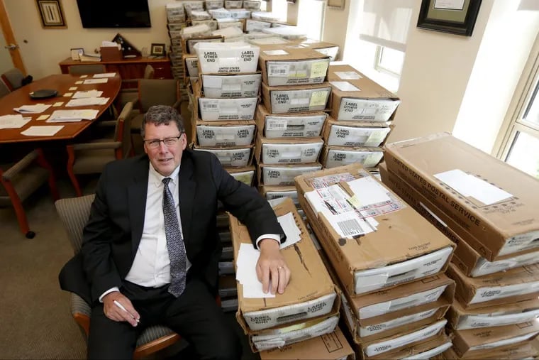 Scott Petri, who is the head of the PPA, sits in his office with boxes of returned mail from the parking ticket amnesty program in Philadelphia. Petri estimates more than  300,000 piece of mail were returned.