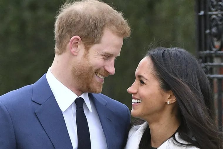 Britain’s Prince Harry and Meghan Markle smile as they pose for the media in the grounds of Kensington Palace in London, Monday Nov. 27, 2017. It was announced Monday that Prince Harry, fifth in line for the British throne, will marry American actress Meghan Markle in the spring, confirming months of rumors. (Dominic Lipinski/PA via AP)
