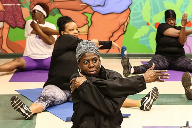 Deborah Montgomery warms up at Chester Housing Authority fitness "Boot Camp" at the Booker T Washington Community Center, Tuesday, April 8, 2014. ( Steven M. Falk / Staff Photographer )