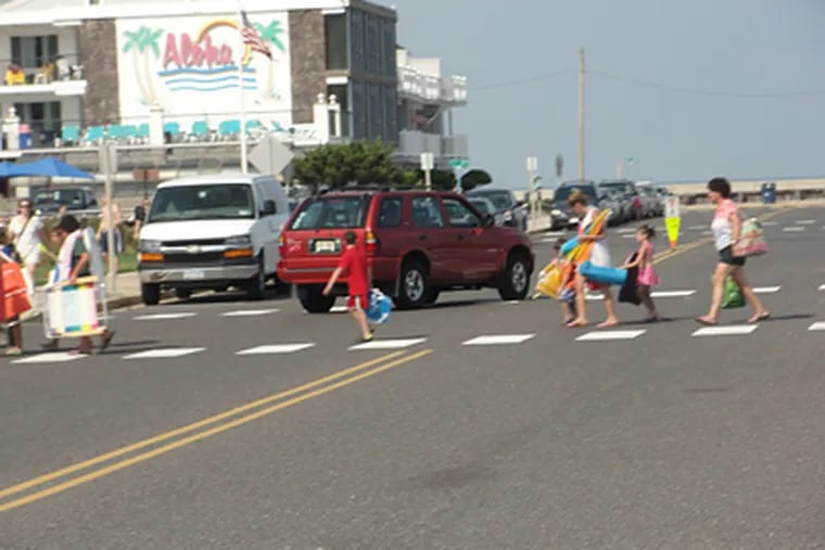 Pedestrians leaving the beach in North Wildwood cross the street at the busy intersection at 3rd and JFK Boulevard.
