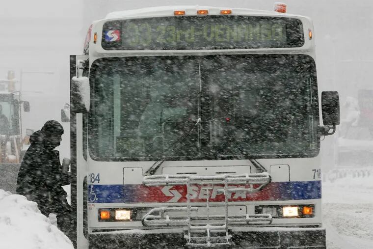 A passenger boards a SEPTA bus during a snow storm along John F. Kennedy Blvd on Wednesday, February 10, 2010.