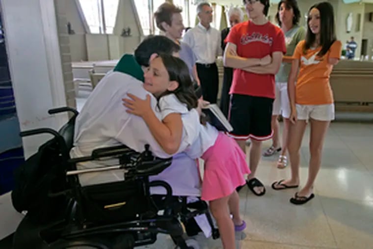 Tori D&#0039;Amico received a birthday blessing from Msgr. Marucci. St. Vincent Palotti has extra-wide aisles and other features that accommodate disabled people.