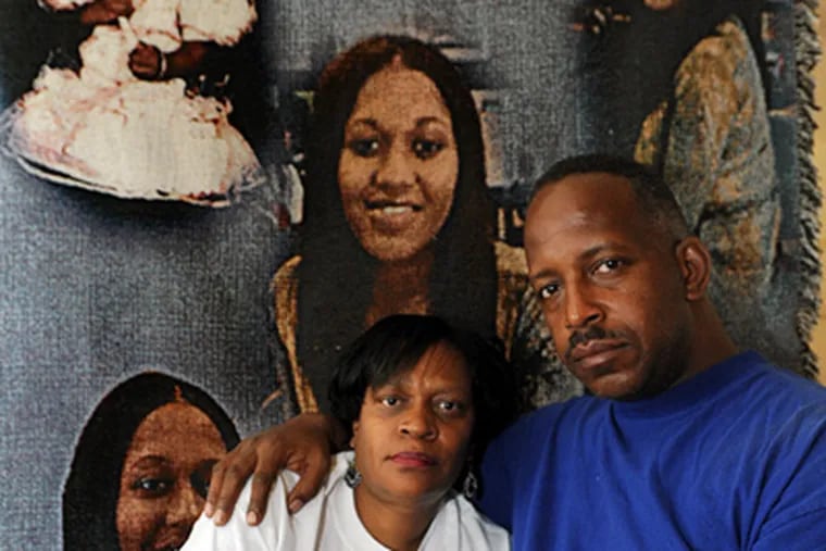 Harry III and Wilma Williams of Pennsauken, parents of Sherita Williams, in front of a memorial blanket. Their daughter was killed in 2003 in a case that went frustratingly cold. (April Saul / Staff Photographer)