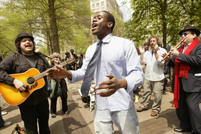 Busted five weeks ago for singing in Rittenhouse Square, Anthony Riley (center) joined protest yesterday.