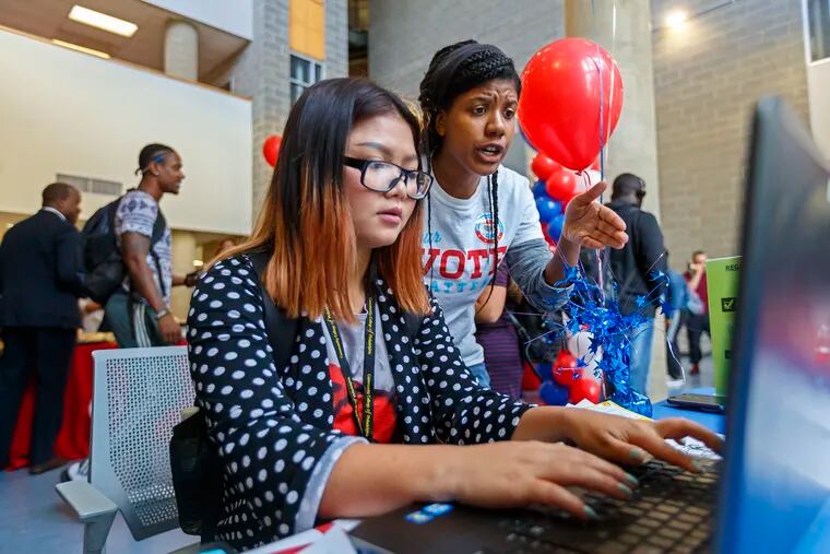 Community College of Philadelphia student Eh Ser Ser Moo, left, gets help from Aminah Sinns, right, from the Campus Elections Engagement Project, as she registers to vote online during the voter registration drive on campus on Sept. 24, 2019.
