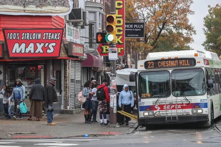 A northbound SEPTA bus on Germantown Avenue stops at the intersection of Germantown and Erie Avenue to pick up passengers next to Max’s Steaks.