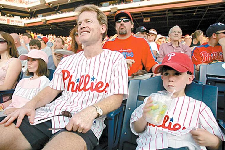Todd Rodzik sits with daughter Caitlin and son Alden at a Phillies game last week with tickets purchased at StubHub. (Barbara L. Johnston / Inquirer)