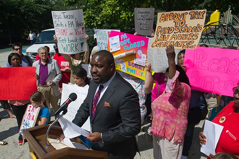Philadelphia City Councilor Kenyatta Johnson leads a rally for state funding for Philly schools with parents, students and district teachers at the playground of Greenfield Elementary School in center city Aug. 5, 2014.  ( CLEM MURRAY / Staff Photographer )