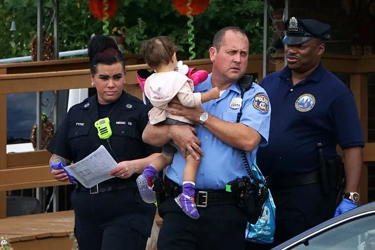 Investigators carry the victim's daughter from a home on Solly Avenue near Ferndale Street in the Fox Chase section of Philadelphia, Monday Sept. 28, 2015, after a 25-year-old woman was fatally stabbed.   (For the Daily News/ Joseph Kaczmarek)