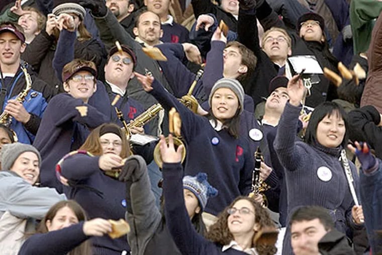 Members of the University of Pennsylvania band take part in the ritual of toast throwing during a Penn/Brown football game in 2002. Given growing poverty and hunger rates, it may be time to rethink that tradition. (Charles Fox / Staff Photographer)