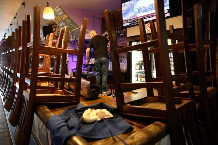 Kevin Lang, bartender at Kostas on Girard Avenue, cleans the bar area in advance of the latest restrictions due to the coronavirus in Philadelphia, PA on March 16, 2020. The bar and restaurant plans to sell beer to go and take-out food.