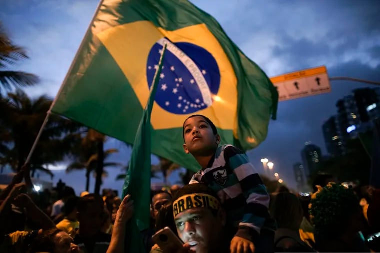 Supporters gather outside the residence of presidential candidate Jair Bolsonaro in anticipation of his victory speech, in Rio de Janeiro, Brazil, Sunday, Oct. 28, 2018. Brazil's Supreme Electoral Tribunal declared the far-right congressman the next president of Latin America's biggest country. (AP Photo/Leo Correa)