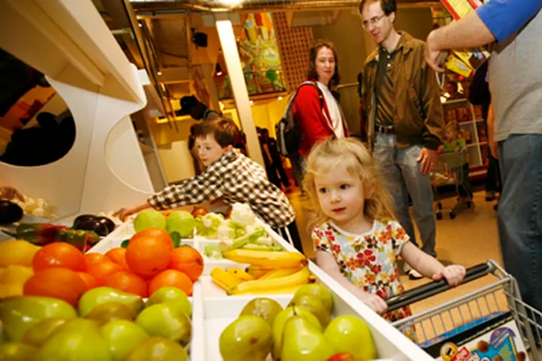 At a preview opening, 3-year-old Willa Salmanson from Narberth "shops" in the supermarket at the Please Touch Museum in Memorial Hall. (Eric Mencher/Staff Photographer)