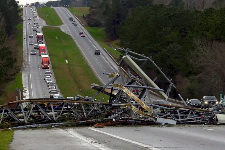 A fallen cell tower lies across U.S. Route 280 highway in Lee County, Ala., in the Smiths Station community after what appeared to be a tornado struck in the area Sunday, March 3, 2019. Severe storms destroyed mobile homes, snapped trees and left a trail of destruction amid weather warnings extending into Georgia, Florida and South Carolina, authorities said. (Mike Haskey/Ledger-Enquirer via AP)