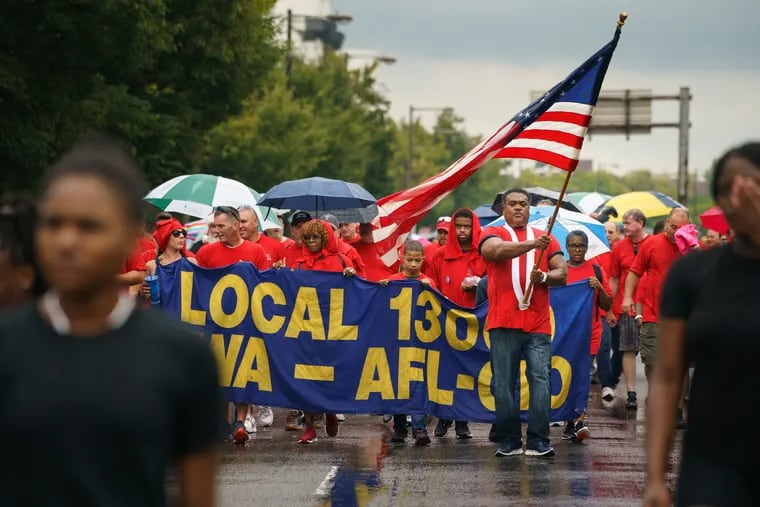 Ken Brown (holding flag) marches with colleagues in the Communications Workers of America Local 13000 AFL-CIO in the Philadelphia Labor Day Parade on Sept. 2. The national AFL-CIO has not endorsed a presidential candidate, though national leaders are skeptical of Medicare for All.