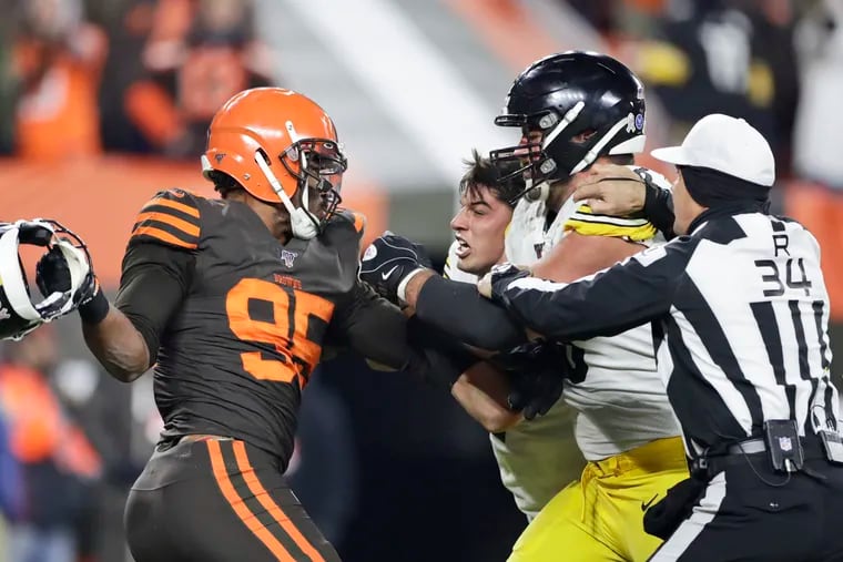 Cleveland Browns defensive end Myles Garrett, left, gets ready to hit Pittsburgh Steelers quarterback Mason Rudolph, second from left, with a helmet during the second half.