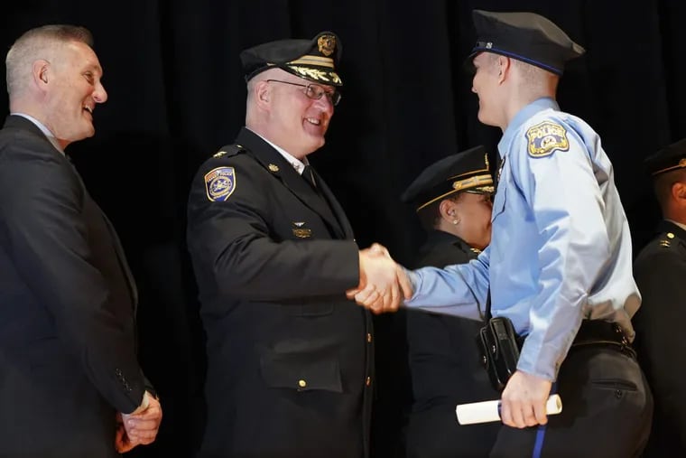 Transit Police Chief Thomas J. Nestel III, center, shakes hands with his son, Philadelphia Police Officer Thomas D. Nestel, during the Philadelphia Police Department graduation ceremony for Class 382, Friday Dec. 15, 2017, at the Temple Performing Arts Center in North Philadelphia.