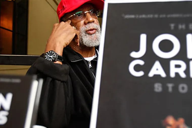 1968 Olympic medalist John Carlos signed copies of his book on Thursday during the Penn Relays. (David Maialetti/Staff Photographer)