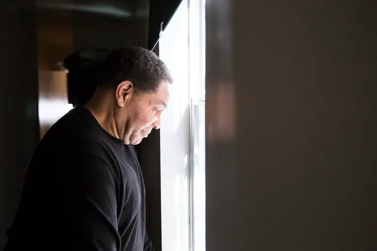 Freddie Nole looks out the window of his nephew's North Philadelphia apartment. Due to an accusation of sexual misconduct that was filed against Nole while he was in prison, but that he never got the opportunity to dispute, Nole's communication with his family members is restricted.