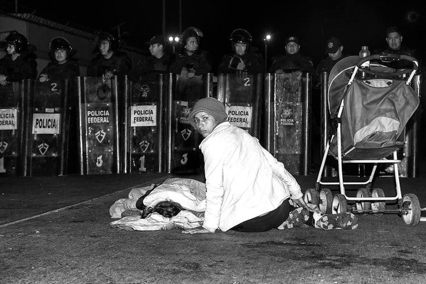 A woman and her child wait at the Mexican border after their long journey from Honduras to seek asylum in the United States.