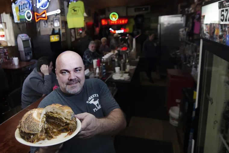 Rob Lucas, third generation owner of Donkey’s Place, shows off  a  signature Donkey’s cheesesteak at the Camden, N.J bar and restaurant.