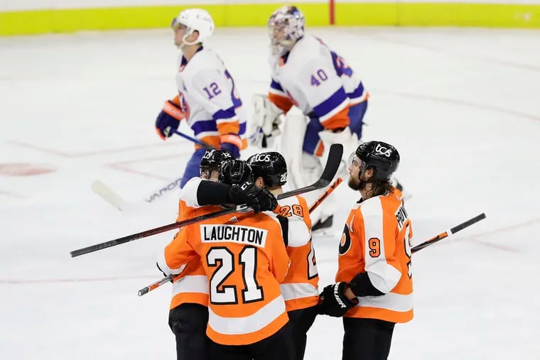 Flyers center Scott Laughton celebrates his game-winning overtime goal with teammates.