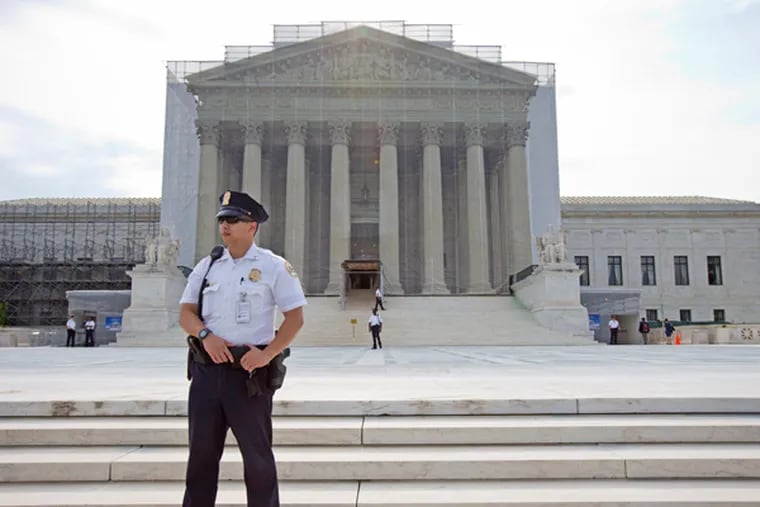 A police officer keeps watch outside the Supreme Court in Washington, Monday, June 17, 2013. With a week remaining in the current Supreme Court term, several major cases are still outstanding that could have widespread political impact on same-sex marriage, voting rights, and affirmative action. (AP Photo/J. Scott Applewhite)
