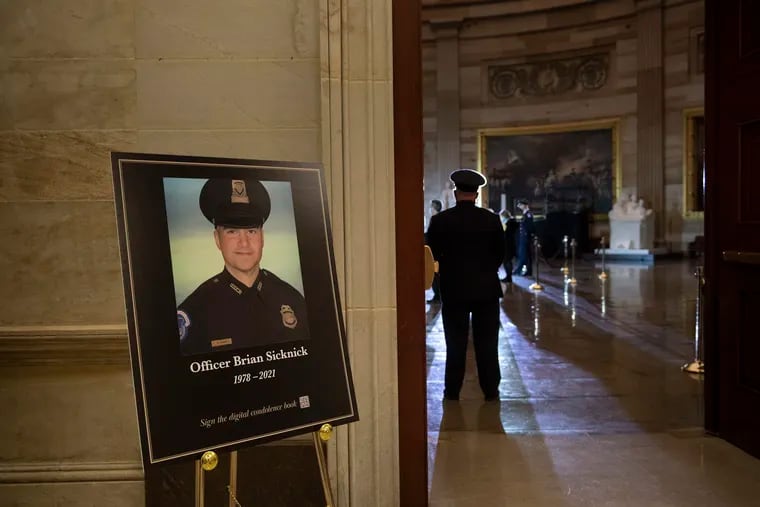 A placard is displayed with an image of the late U.S. Capitol Police Officer Brian Sicknick as people wait for an urn with his cremated remains to be carried to lie in honor in the Capitol Rotunda in Washington on Feb. 2.