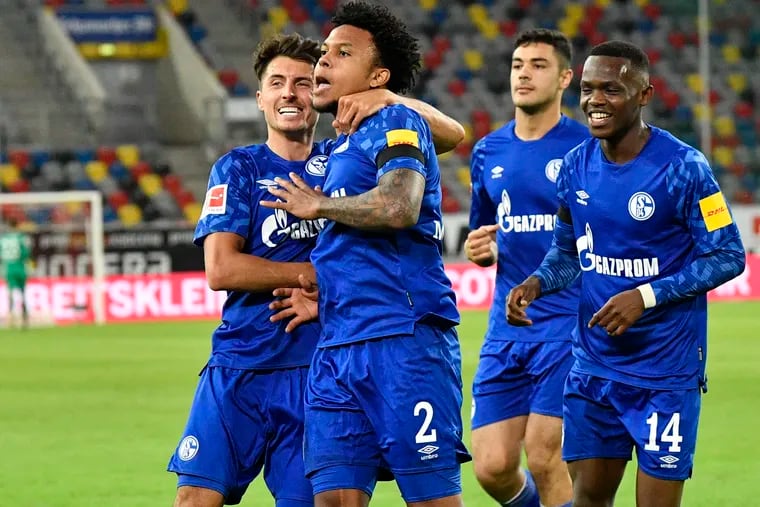 Schalke's American midfielder Weston McKennie (2) celebrates with teammates - albeit not in a socially-distanced way - after scoring a goal against Fortuna Düsseldorf on Wednesday.