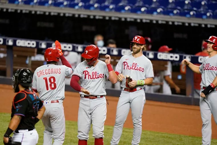 Didi Gregorius (18) is congratulated by Rhys Hoskins, Bryce Harper, and J.T. Realmuto, after hitting a Grand Slam in the first inning Saturday night against Miami.