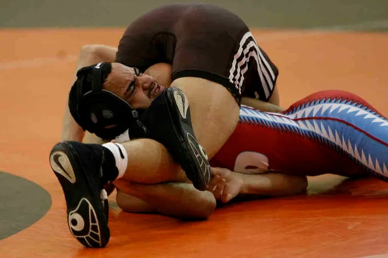 Pennsauken's Ricky Harkins grimaces as he is pinned by Cherokee's D.J. Mele in the 119-pound bout. Cherokee had six pins and two major decisions in nine wins en route to the 47-20 win.