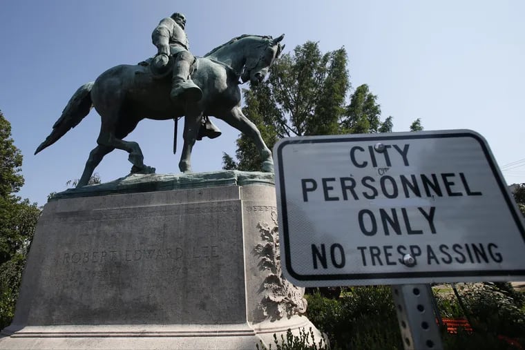 In this Monday, Aug. 6, 2018 photo, a No Trespassing sign is displayed in front of a statue of Robert E. Lee in Charlottesville, Va., at the park that was the focus of the Unite the Right rally.
