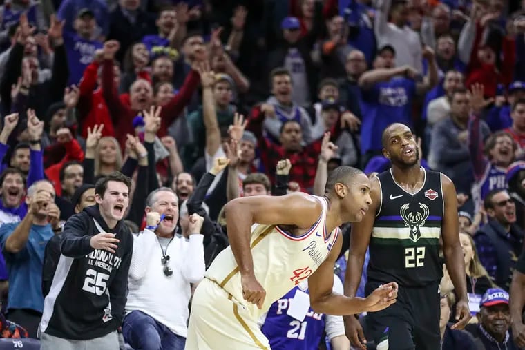 Sixers fans react behind Al Horford after he hits a three-pointer late in the fourth quarter over Khris Middleton (22) of the Milwaukee Bucks.