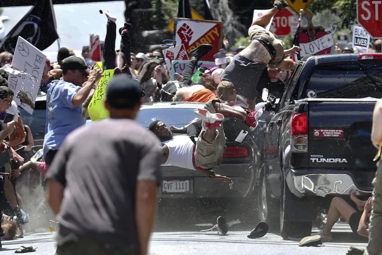 FILE – In this Aug. 12, 2017 file photo, people fly into the air as a vehicle is driven into a group of protesters demonstrating against a white nationalist rally in Charlottesville, Va. James Alex Fields Jr., the man accused of driving into the crowd demonstrating against a white nationalist protest, killing one person and injuring many more, is to be tried on a charge of first-degree murder.