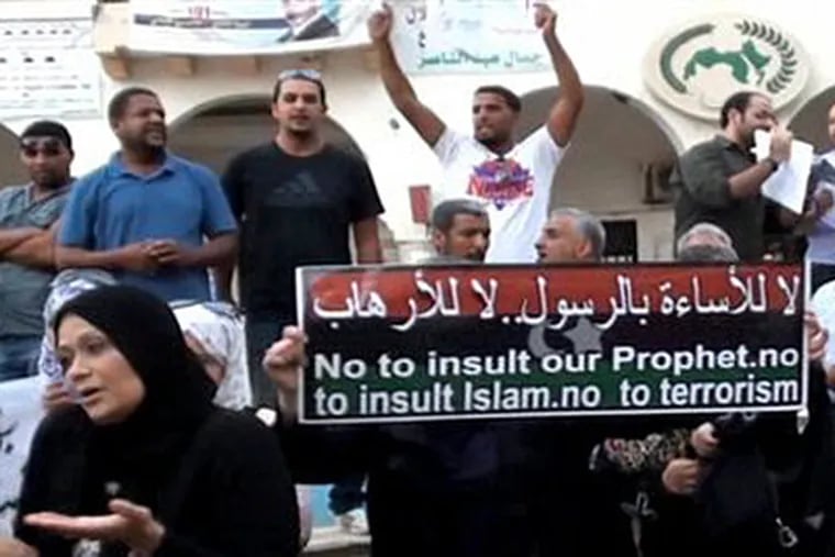This video image taken from AP video shows protestors holding a sign during a demonstration in the eastern Libyan city of Benghazi to protest Tuesday's attack on the US Consulate and the subsequent killing of Ambassador Chris Stevens, Wednesday, Sept. 12, 2012. (AP Photo/AP video)