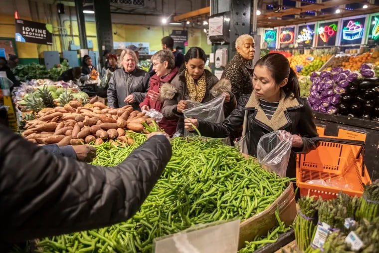 Produce shoppers at Iovine Brothers at the Reading Terminal Market look for the best green beans as they shop for what they need for their Thanksgiving dinner.