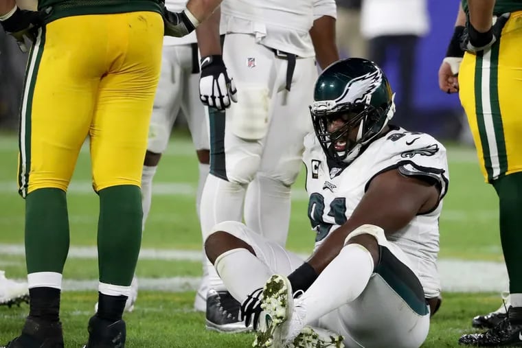 Eagles defensive tackle Fletcher Cox grabbed his right leg after he was injured against the Packers.